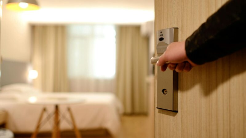 person holding on door lever inside room