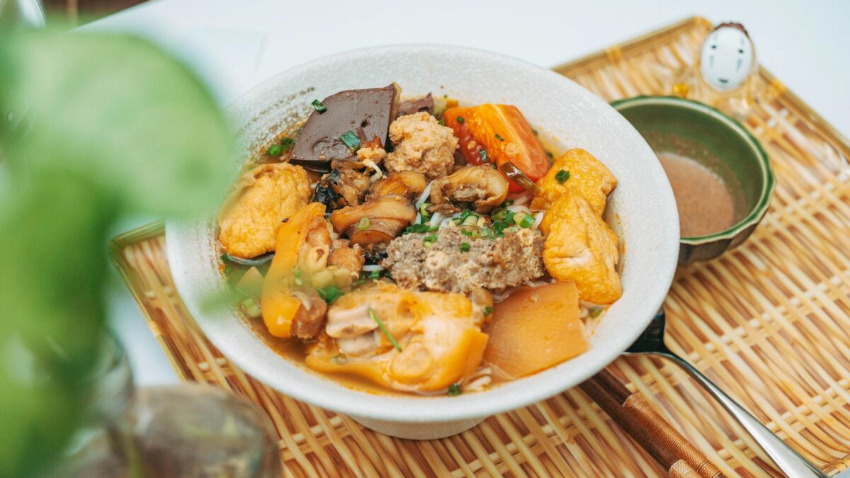 a bowl of food with meat and vegetables on a plate