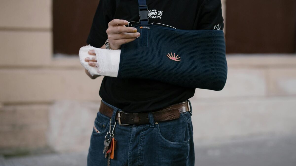 person with blue bandage on his injured arm